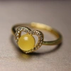 A 15-year-old store has a heart-shaped ring with a white jade crystal bead, amber and copper setting Application Scenario